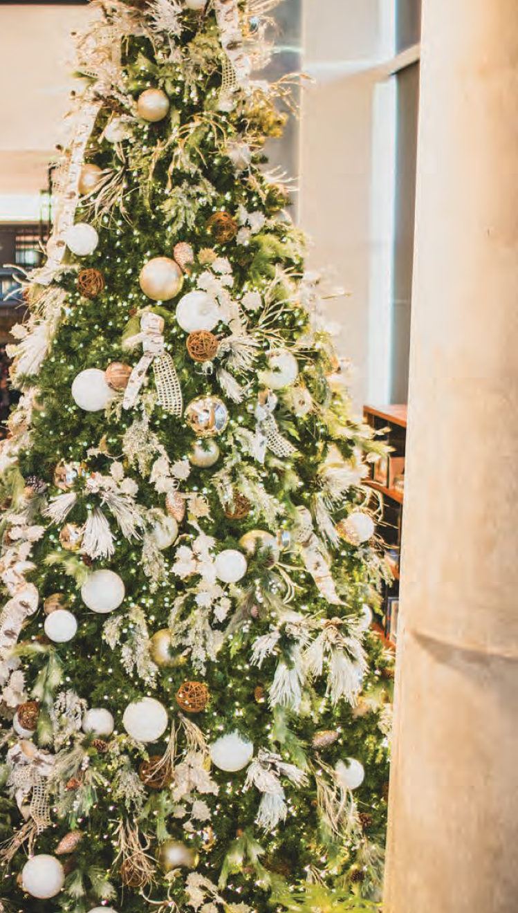 Close view of a decorated commercial tree with white and gold ornaments